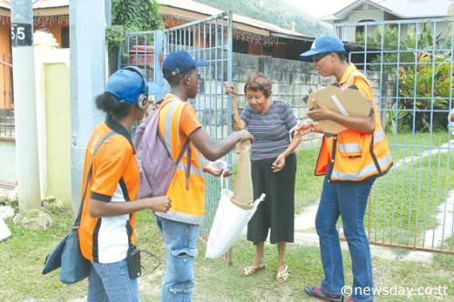 Officials of the Office for Disaster Preparedness and Management (ODPM) give a disaster survival kit to an elderly resident yesterday during a distribution drive in Diego Martin aimed at equipping residents with basic disaster survival items. Author: RATTAN JADOO