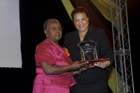 Edward Williams. Caption: Dawn Smith (left) collects Regional Unsung Hero Awardee 2012 Edward Williams’ award on his behalf from Managing Director, HR, CIBC FirstCaribbean, Ella Hoyos.
