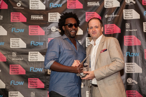 Damian Marcano, director of God Loves a Fighter, collecting an award. Photo courtesy arcthemagazine.com