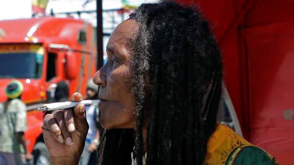 A man smokes marijuana during a pro-legalisation demonstration in Kingston. Photo courtesy http://news.sky.com/