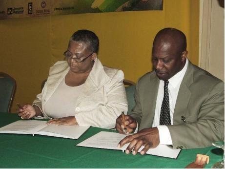 Marlene Street-Forrest and Denis St Bernard signing the MOU on Friday at the Diaspora Convention at Sunset Jamaica Grande Resort in Ocho Rios, St Ann. - contributed