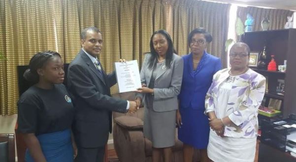 Williams presenting the petition to Minister Alvina Reynolds. Photo courtesy http://www.stlucianewsonline.com