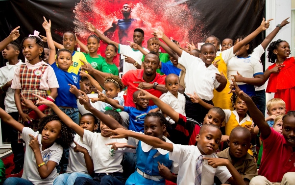 Digicel invited aspiring little newshounds from across the Caribbean to a kiddie press conference with Usain Bolt, the world's fastest man in the hot seat. The kiddie press pack surrounds Usain for an impromptu lightning bolt having peppered him with probing questions like "How many girlfriends do you have?" and "What do you think of vegetables?" in Kingston, Jamaica on Tuesday. Photo courtesy http://www.prnewswire.com