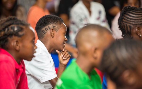 Die hard Bolt fan, nine year-old Kareem Davis from St. Vincent and the Grenadines, is all ears as Usain fields questions from the kiddie press pack at the Digicel "Bring the Beat" launch. Photo courtesy http://www.prnewswire.com
