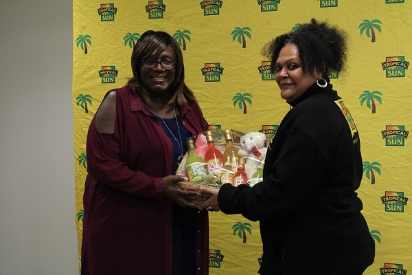 Dawn Lindo-Morgan receiving her Jewel Isle Rum Punch hamper from Tropical Sun's Vaseva Qarau. Photo courtesy CaribDirect